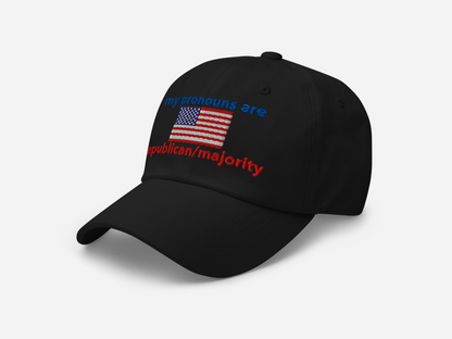 A black dad hat featuring "my pronouns are republican/majority" embroidery with detailed a American flag design, shown from the left-front angle, emphasizing the clean, adjustable strap, structured fit and highlighting the curved brim and stitching details