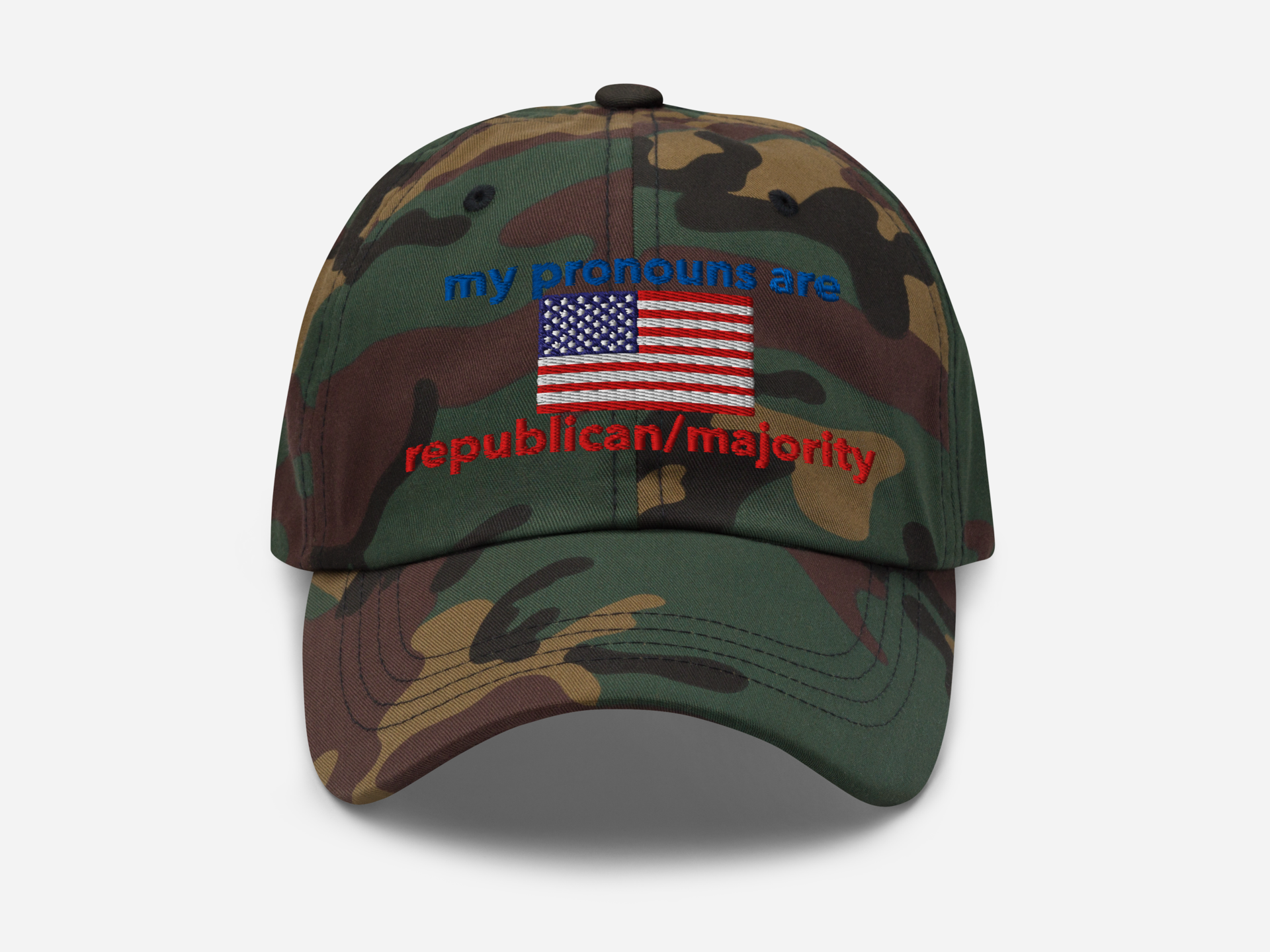 A green camouflage dad hat with the embroidered text "my pronouns are republican/majority" in bold red and blue, featuring a detailed American flag design at the center, viewed from the front