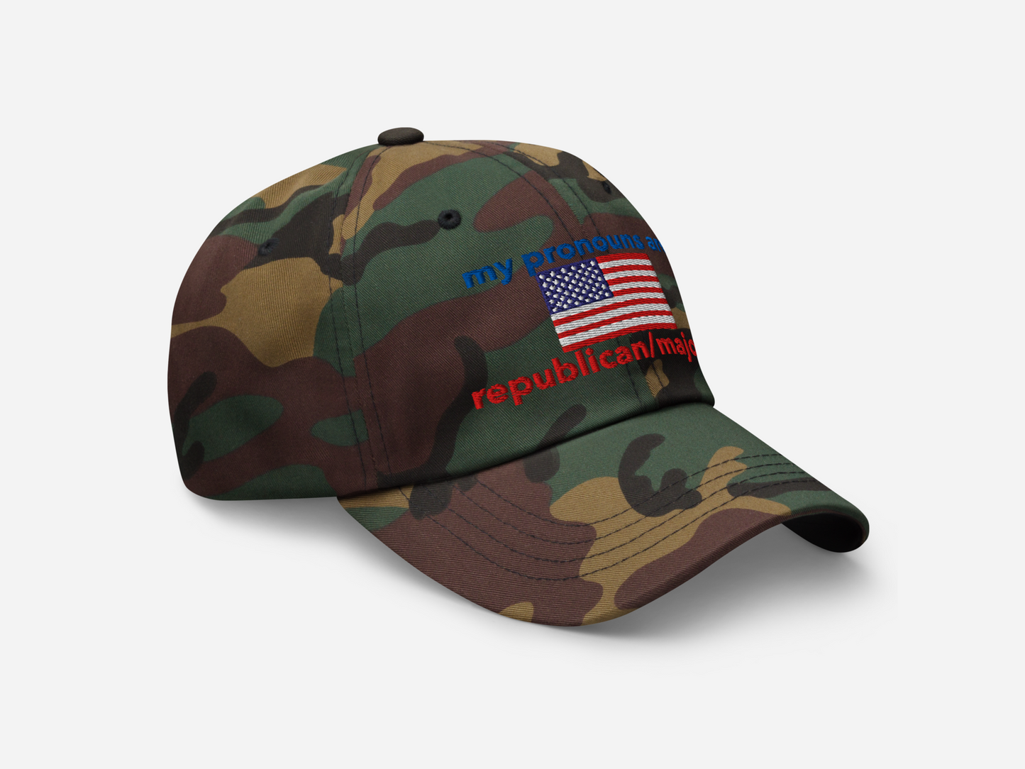 A green camouflage dad hat featuring "my pronouns are republican/majority" embroidery with detailed a American flag design, shown from the right-front angle, emphasizing the clean, adjustable strap, structured fit and highlighting the curved brim and stitching details