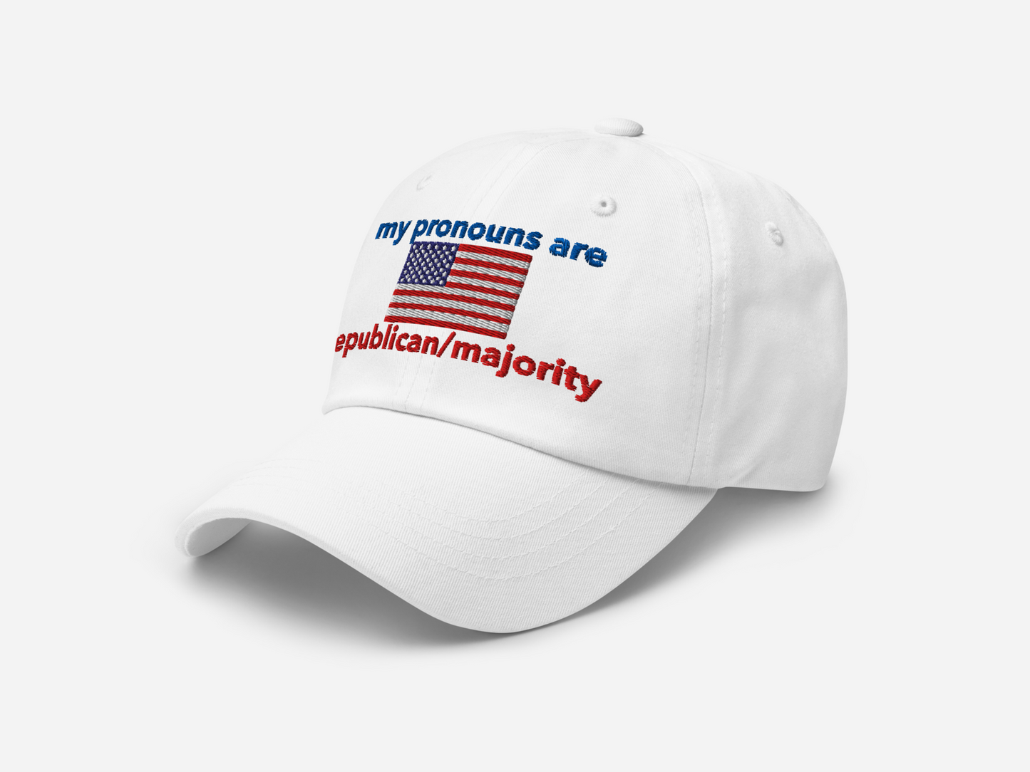 A white dad hat featuring "my pronouns are republican/majority" embroidery with detailed a American flag design, shown from the left-front angle, emphasizing the clean, adjustable strap, structured fit and highlighting the curved brim and stitching details