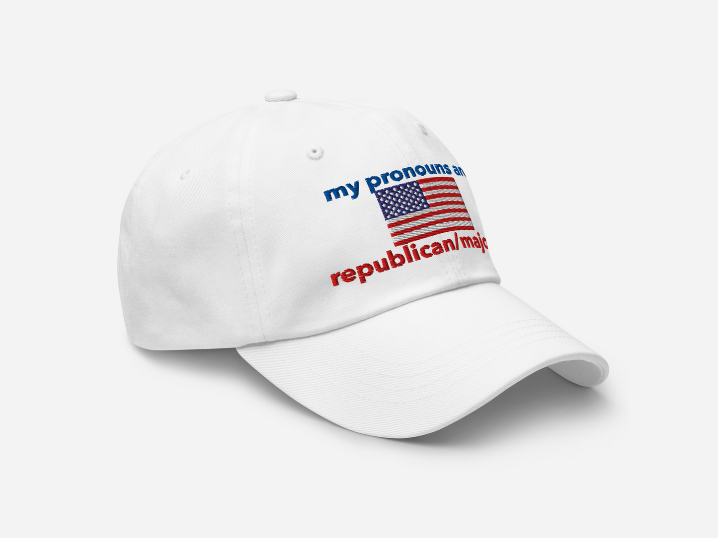 A white dad hat featuring "my pronouns are republican/majority" embroidery with detailed a American flag design, shown from the right-front angle, emphasizing the clean, adjustable strap, structured fit and highlighting the curved brim and stitching details